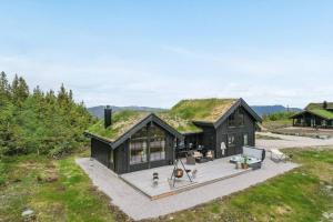 an image of a black house with a grass roof at Cabin with jacuzzi on Lifjell in Lifjell