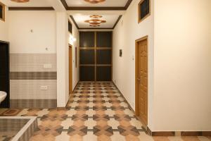a hallway with a door and a checkered floor at Sudama Dham Homestay in Ayodhya