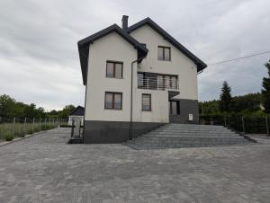 a large white house with stairs in a driveway at Noclegi pod gora in Oboźna Droga Masłów