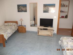 a living room with two beds and a flat screen tv at Villetta Mare Ventotene in Ventotene