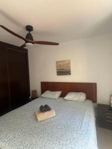 a bedroom with a bed with two pillows and a ceiling fan at Fuerteventura Atlantic Gardens Corralejo in Corralejo