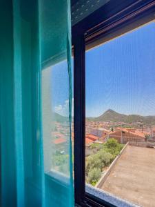 une fenêtre avec vue sur la ville dans l'établissement Brebei Niedda Hostel, à Gonnesa