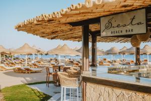 a beach bar with chairs and tables and umbrellas at Baron Palms Adults Friendly Only 16 years plus Boutique Hotel Style in Sharm El Sheikh