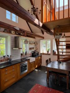 a kitchen with wooden cabinets and a table in it at Hönshuset Kullabygden in Höganäs