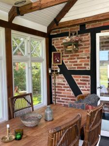 a dining room with a table and a brick wall at Hönshuset Kullabygden in Höganäs