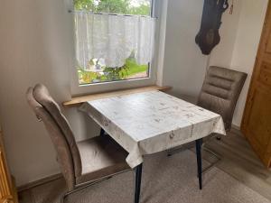 a table and chairs in a room with a window at Ferienwohnung -Bernie EG Sandhorst in Aurich