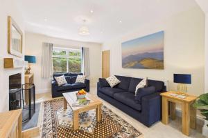 a living room with a blue couch and a table at Host & Stay - Merrow Cottage in Great Malvern +27 photos