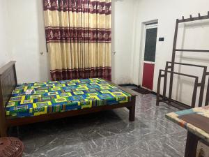 a bed sitting in a room with a curtain at Aadham rest in Madawala