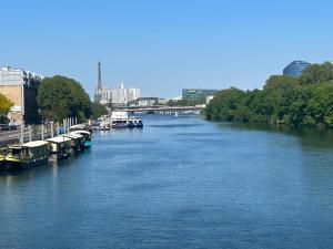 ブローニュ・ビヤンクールにあるSUNNY Studio 2 steps from metroの川の横に船が停まっている