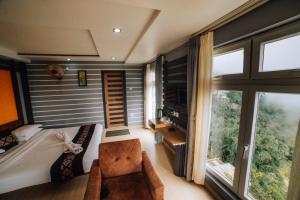 a bedroom with a bed and a large window at Amarjeet Hotel in Kurseong