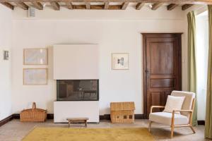 a living room with a tv and a chair at Alfred Hotels Beaune La Madeleine in Beaune