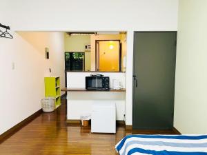 a room with a bed and a kitchen with a microwave at アルピエj107号室無料Wi-Fiあり熊本城徒歩5分 in Kami-kumamoto