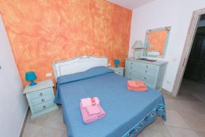 a bedroom with a bed with two pink towels on it at Appartamento Mariposa in Orosei