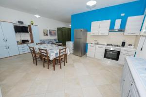 a kitchen with a table and chairs and a blue wall at Appartamento Mariposa in Orosei