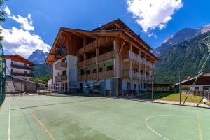 a building with a tennis court in front of it at Apartments Sunseit'n in Sesto