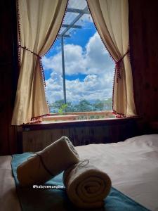 a bedroom with a window with a towel on a bed at Một Homestay Mang Den in Kon Von Kla