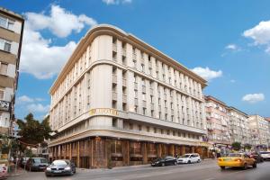 ein hohes weißes Gebäude mit Autos auf einer Straße in der Unterkunft Berr Hotel in Istanbul