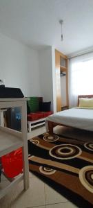 a bedroom with a bed and a table and a rug at Studio solace kitisuru in Nairobi