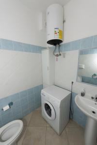 a bathroom with a washing machine and a sink at Appartamento Mariposa in Orosei