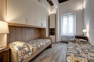 a bedroom with two beds and a window at La casina delle 6M in Florence