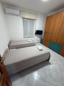 a bedroom with two beds and a tv and a window at Palazzo SantAntonio Apartament in Naples