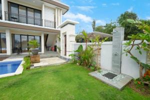 a house with a garden and a swimming pool at Gula Busa Guest House in Ketewel