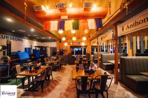 a restaurant with tables and chairs in a room at Amarjeet Hotel in Kurseong