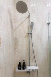 a shower with two bottles on a shelf in a bathroom at Eva Adam Hotel in Ho Chi Minh City