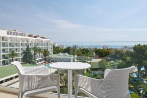 a balcony with a table and chairs and a building at Grupotel Gran Vista & Spa in Can Picafort