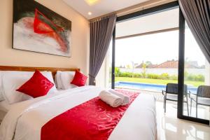 a bedroom with a large bed with red pillows at Gula Busa Guest House in Ketewel