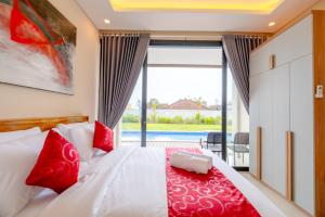 a bedroom with a bed with red pillows and a window at Gula Busa Guest House in Ketewel +26 photos