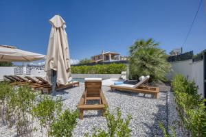eine Terrasse mit Stühlen und einem Sonnenschirm und einem Sonnenschirm in der Unterkunft Villa Elisadora in Poreč