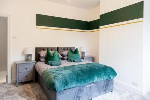 ハイドにあるTwo Bedroom House By Brookland Stays Serviced Accommodation Short Lets Manchester With Free WiFiの緑の枕が付いた大きなベッドのある寝室 +2枚の写真