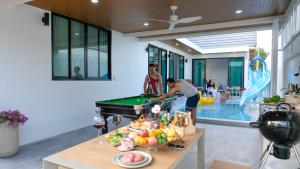 a man playing pool in a living room with a pool table at Wana Villa ChaAM in Nikhom Sang Ton Eng Khuan Phet