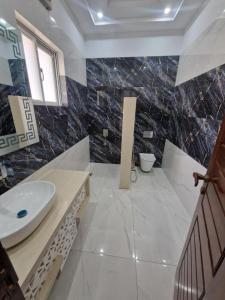 a bathroom with a sink and a toilet in it at The Luxe Nook in Islamabad