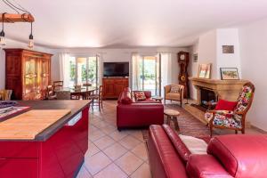a living room with a red couch and a fireplace at La Gloriette d'Oustaou - au coeur du Verdon in Régusse