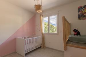 a baby room with a crib and a window at Morgon Garden Lodge - Proche de la Rivière in Savines