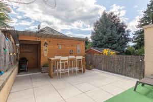 a patio with a table and chairs in a backyard at Morgon Garden Lodge - Proche de la Rivière in Savines