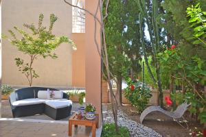 un patio con sofá, mesa y árboles en Amparo Luca, en Puerto de Alcudia