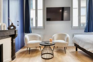 une chambre avec un lit, deux chaises et une table dans l'établissement Le Marie superbe studio au coeur de Rouen, à Rouen