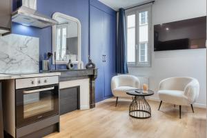 une cuisine avec des murs bleus et une table et des chaises dans l'établissement Le Marie superbe studio au coeur de Rouen, à Rouen