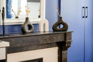 deux vases assis au-dessus d'une cheminée dans l'établissement Le Marie superbe studio au coeur de Rouen, à Rouen 14 autres photos