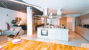 a kitchen and living room with a table and a dining room at Coliving moderno com lindo jardim in Porto