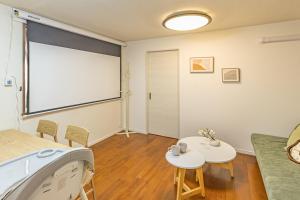 a living room with a large window and a table and chairs at Asakusa Cozy Japanese House with Tatami & Projector, 5min to Station in Tokyo