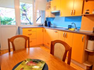 a kitchen with orange cabinets and a table and chairs at Nida Amber in Nida +16 photos