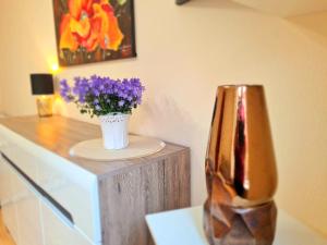 a vase with purple flowers sitting on a counter at Nida Amber in Nida