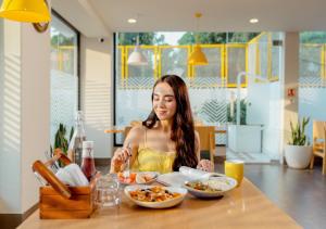 a woman sitting at a table eating food at Bloom Boutique l Sector 45 Gurugram in Gurgaon