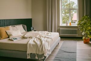 ein Schlafzimmer mit einem Bett und einem Fenster in der Unterkunft Hotel Kaķītis in Sigulda
