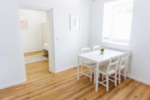 a white dining room with a white table and chairs at Ferienwohnung Zur Wieskapelle W3 - ideal für Monteure in Straubing