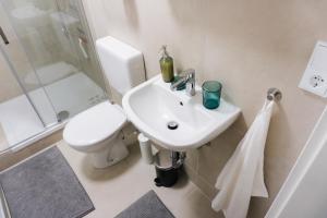 a white bathroom with a toilet and a sink at Ferienwohnung Zur Wieskapelle W3 - ideal für Monteure in Straubing